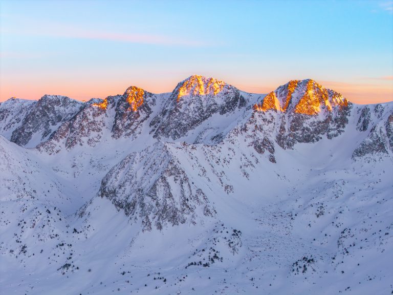 Muntanyes nevades del Pirineu Catala amb la posta de sol iluminant els cims